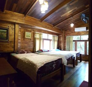 Klong Suan Plue Resort في فرا ناخون سي أيوتثايا: سريرين في غرفة بجدران خشبية