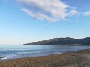 a beach with the ocean and mountains in the background at Sunny summer time in Nea Vrasna +3 photos