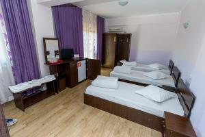 um quarto de hotel com duas camas e um espelho em Pensiunea Domneasca em Piteşti