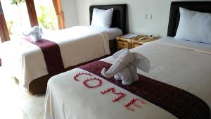 Habitación con 2 camas y un elefante relleno en la cama en Star Sand Beach Resort, en Sekotong 54 fotos más