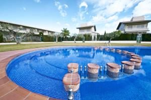 uma piscina com bancos numa casa em Casa Joana em L'Ampolla