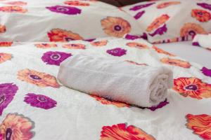 Una toalla blanca sobre una cama con flores en Apartment Resaa, en Bihać