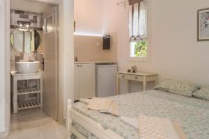 a bedroom with a bed and a sink and a kitchen at Villa Jasmin Studios in Gouvia
