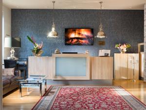 a living room with a large tv and a couch at Hotel Ambassador-Berlin Grünau in Berlin