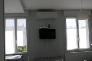 a room with three windows and a flat screen tv at Studio proche gare St Jean in Bordeaux