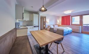 a kitchen and living room with a table and a bed at Appartements Gappmaier in Saalbach Hinterglemm