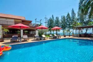 a swimming pool with chairs and umbrellas at Palm Beach Resort in Pran Buri