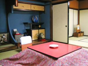 a dining room with a red table and a chair at Sumiyoshi Ryokan in Takayama