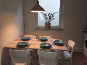 a dining room table with green plates and chairs at Apothekerwohnung in Friesoythe