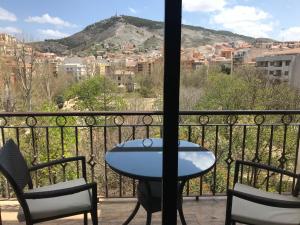 Una mesa y sillas en un balcón con vista. en Hotel Alfonso VIII De Cuenca, en Cuenca
