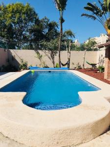 a swimming pool with blue water in a yard at Casa Balam in Rincon de Guayabitos
