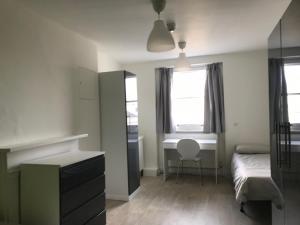 ロンドンにあるLeinster House (Bayswater)の机とベッドと窓のある寝室