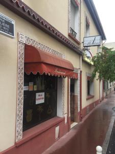 蒙魯日的住宿－巴黎蒙魯日莫里哀酒店，街上有红色遮阳篷的商店
