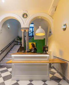 a woman sitting at a desk in a building at Oasis Backpackers' Palace Seville in Seville
