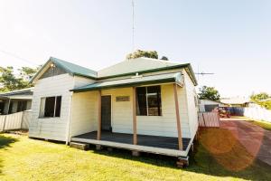 una piccola casa bianca con portico di Coal d' Vine Cottage - Cessnock NSW a Cessnock