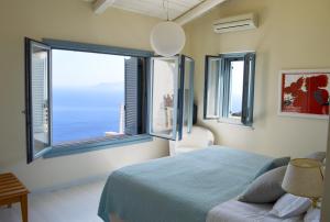 a bedroom with a bed and a large window at Urania Luxury Villas in Vasiliki
