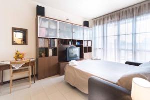 een slaapkamer met een groot bed en een televisie bij Suite Carpiano in Melegnano