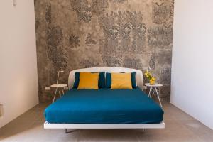 シラクーサにあるResidenza Nereoのベッドルーム1室(青と黄色の枕が備わるベッド1台付)