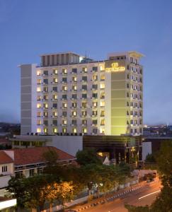 een groot gebouw met een bord aan de zijkant bij Hotel Santika Pandegiling - Surabaya in Surabaya