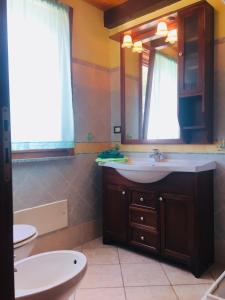bagno con lavandino e specchio di Green House a Porto Pino