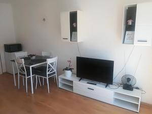 ein Wohnzimmer mit einem Tisch und einem Flachbild-TV in der Unterkunft Apartman Franc in Zadar