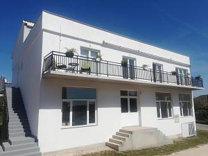 ein weißes Haus mit Balkon darüber in der Unterkunft Apartman Franc in Zadar