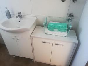 ein Badezimmer mit einem Waschbecken, einem WC und einem Spiegel in der Unterkunft Apartman Franc in Zadar