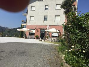 un edificio con mesas y sombrillas frente a un edificio en Albergo Ristorante La Greppia, en Montedivalli Chiesa