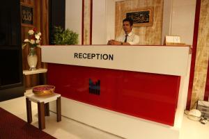 a man is standing behind a reception desk at HOTEL MADNI ROYALE (50 Mtrs from Dargaah), Ajmer in Ajmer