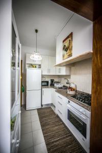 a kitchen with white cabinets and a white refrigerator at Dream city home 2 in Caldas da Rainha