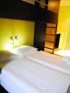 2 Betten in einem Schlafzimmer mit 2 Lampen an der Wand in der Unterkunft Bridge Inn Hotel Hamburg in Hamburg