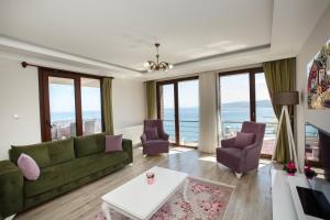 a living room with a green couch and purple chairs at North Pearl Residence in Trabzon