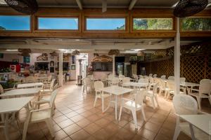 a restaurant with white tables and white chairs at Camping Nube D'Argento in Sorrento