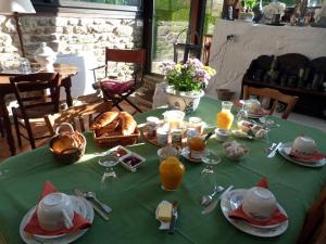 una mesa con un mantel verde con comida. en Chambres d'hôtes Logis Du Jerzual, en Dinan