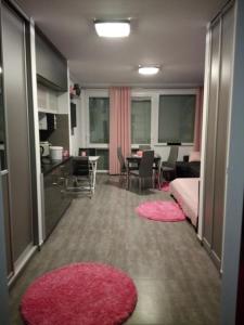 a room with a kitchen and a living room with pink rugs at Apartament Slavia Rosa in Międzyzdroje