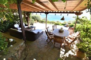 a patio with a table and chairs and a couch at Blue Bay View - Beach House in Vathírrevma