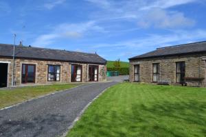 an old stone house with a grass yard in front of it at Fernhill Bed and Breakfast in Rochdale