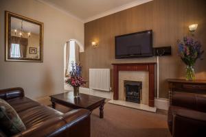 a living room with a couch and a fireplace at Devonshire Park Hotel in Eastbourne
