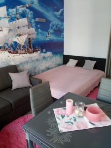 a room with a couch and a table with a ship mural at Apartament Slavia Rosa in Międzyzdroje
