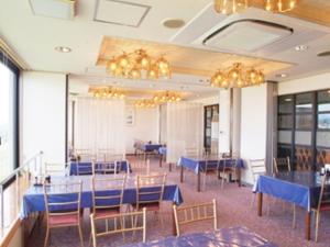 a dining room with blue tables and chairs and chandeliers at Smile Hotel Koriyama in Koriyama