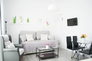 salon z kanapą i stołem w obiekcie Casas y Patios de Sevilla w Sewilli
