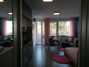a living room with a couch and a dining room at Apartament Slavia Rosa in Międzyzdroje