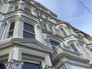 a tall white building with windows and a sky at Halvard Hotel in Douglas