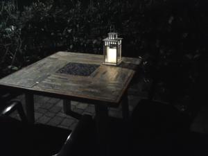 a light sitting on a wooden table at night at La Casa di Ulisse B&B in Quercianella