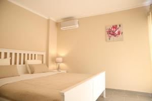 ポルティマンにあるBeco Do Sol Apartment T2のベッドルーム1室(ベッド1台付)が備わります。壁に絵が飾られています。