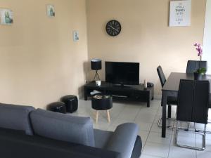 sala de estar con sofá, mesa y TV en L'escapade tannaysienne, en Tannay