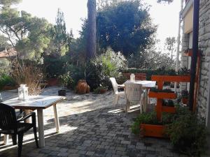 a patio with tables and chairs on a brick patio at La Casa di Ulisse B&B in Quercianella
