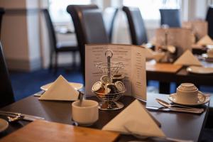 a table in a restaurant with a tea set on it at OYO Devonshire Park Hotel in Eastbourne
