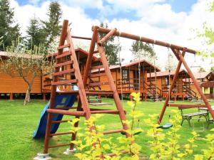 a wooden play structure in front of a house at U Synowców in Polańczyk