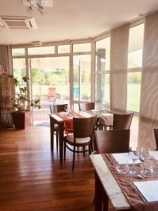 a dining room with a table and chairs and windows at Hôtel Restaurant Evan in Lempdes sur Allagnon